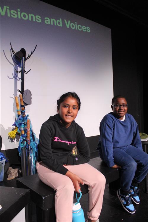 Boy and girl sit on stage